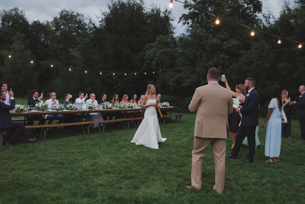 The whole party at farm tables at dusk