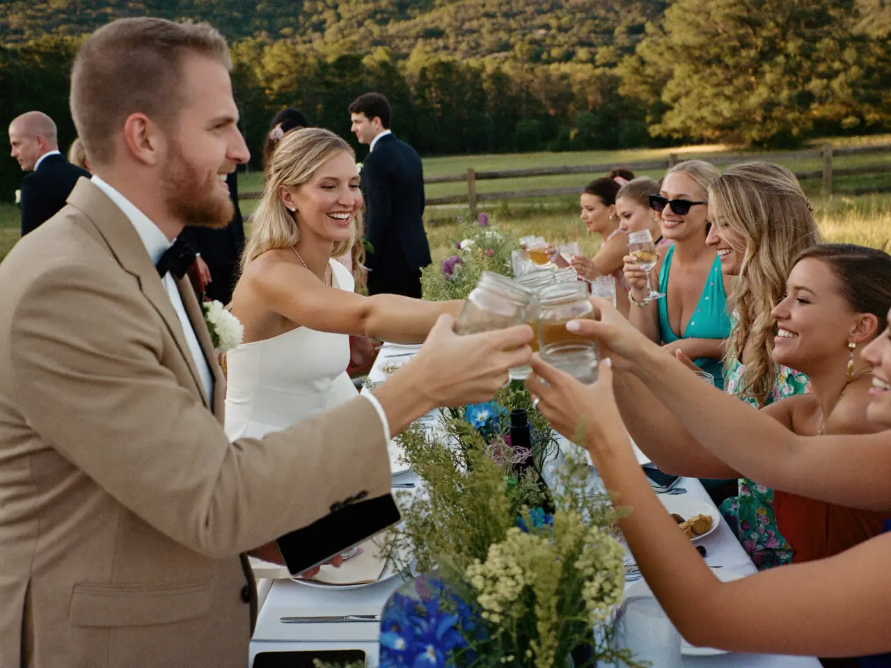Guests clinking glasses across the farm table