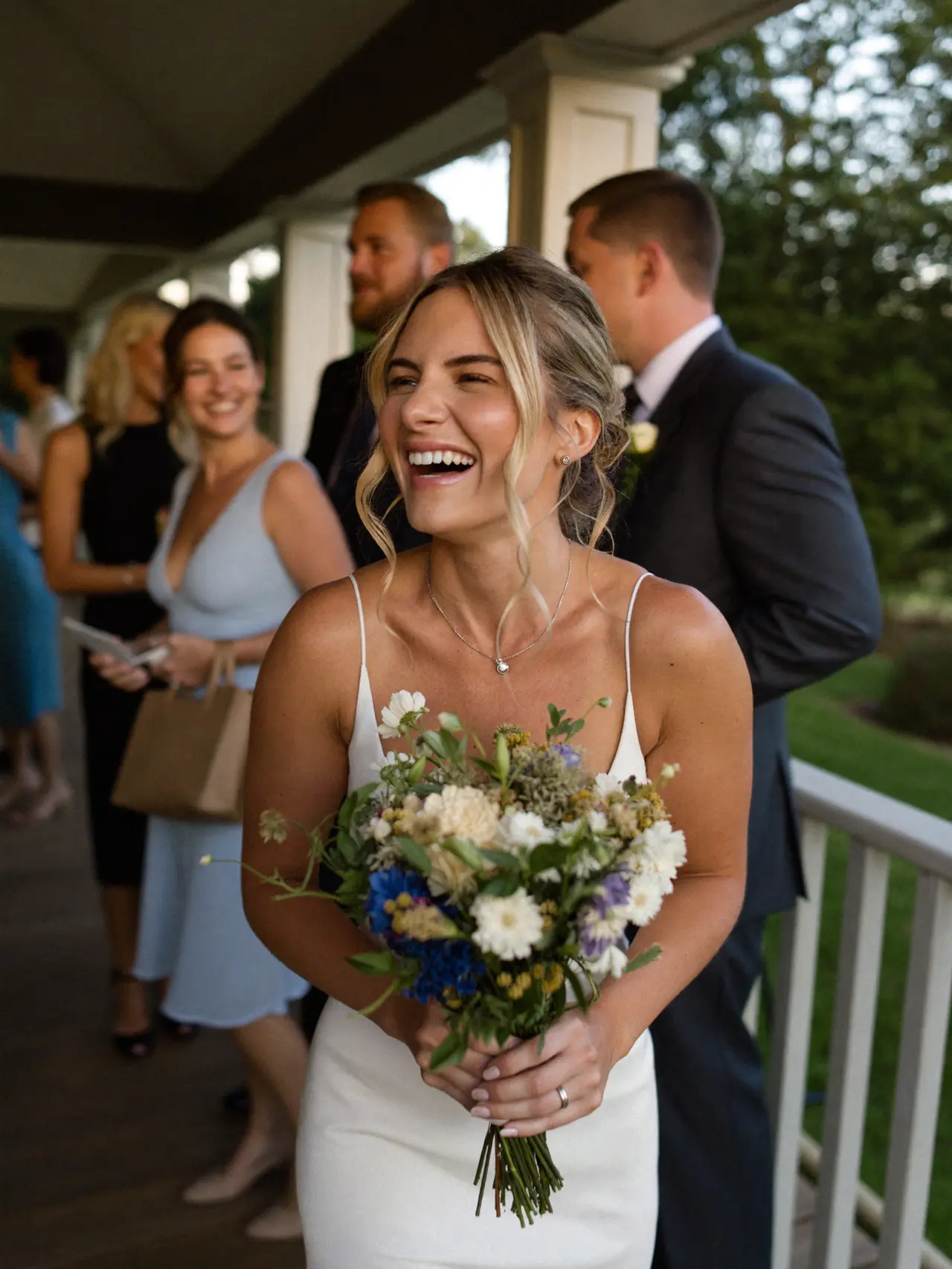 The bride laughing on the porch at golden hour