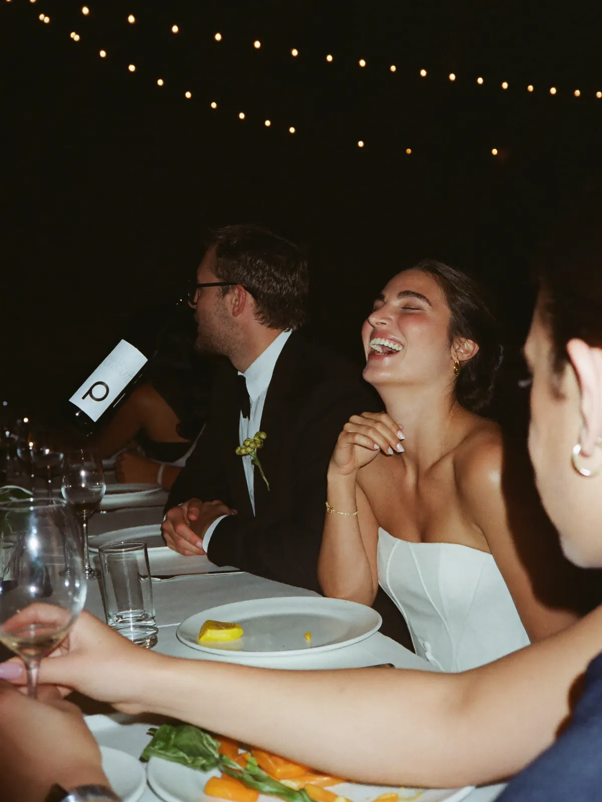 The couple listening to a toast at the head table