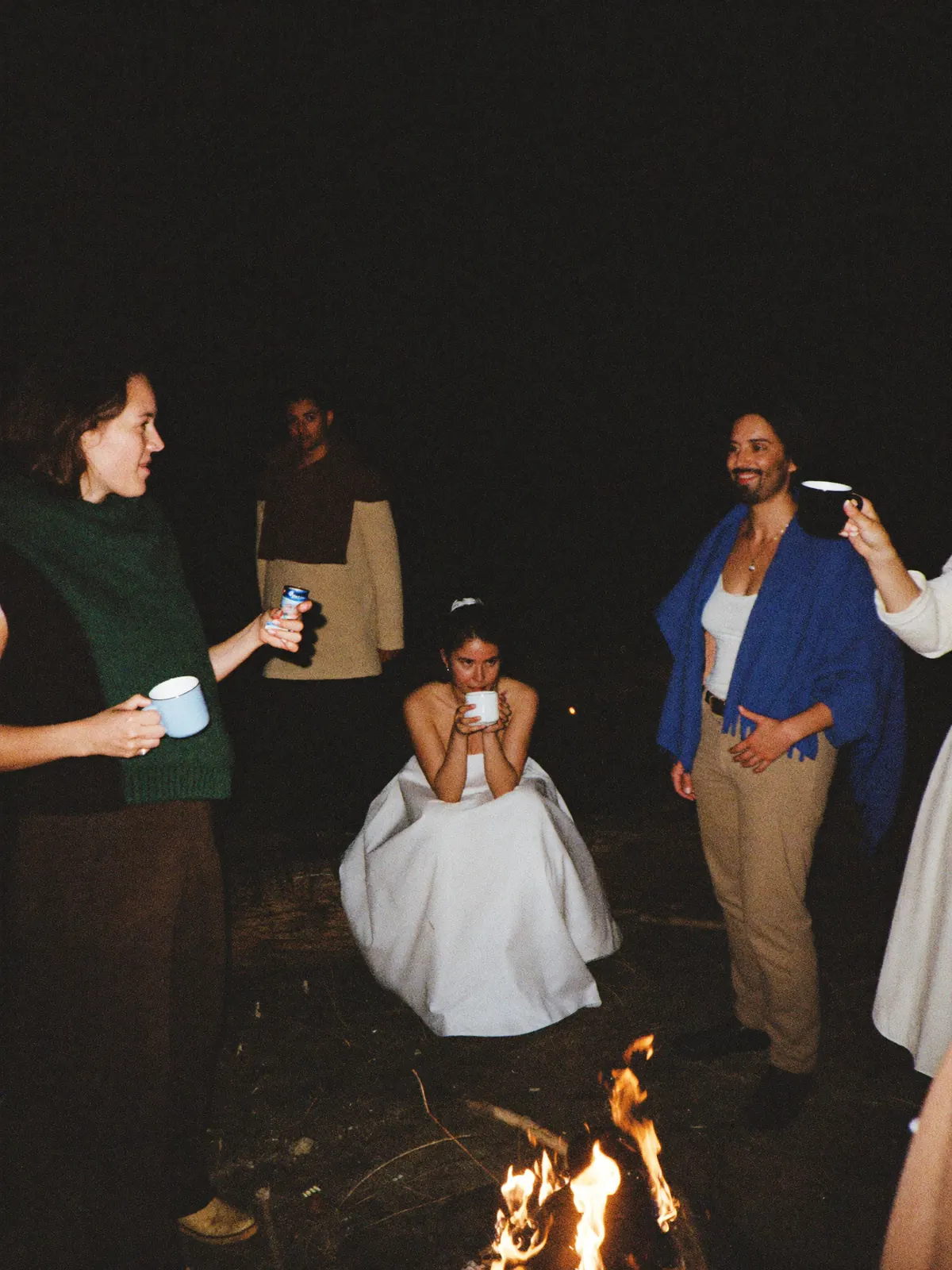 Guests around the fire pit after the barn reception, blankets over their shoulders
