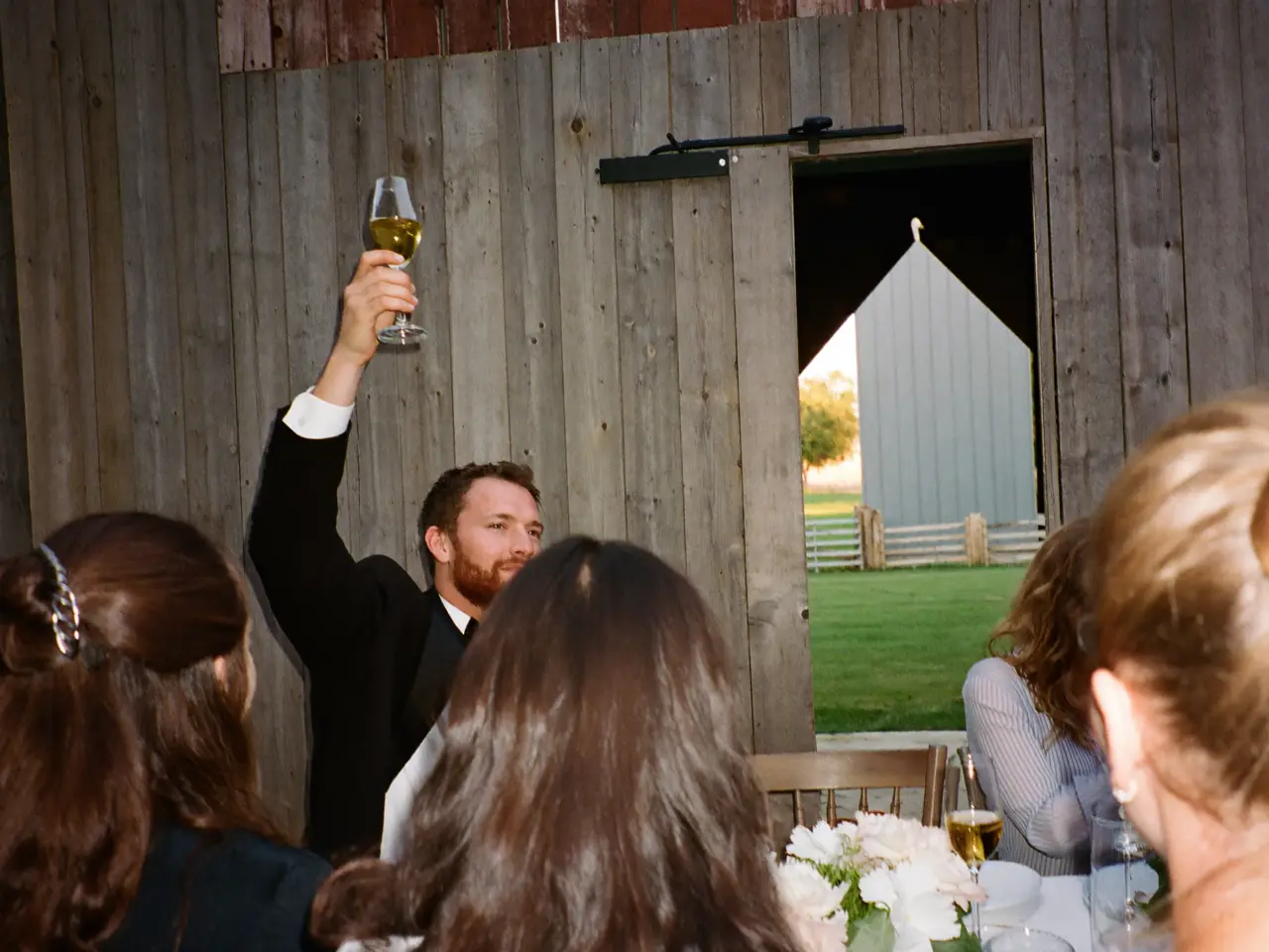 Guests raising phones during a toast at a reception