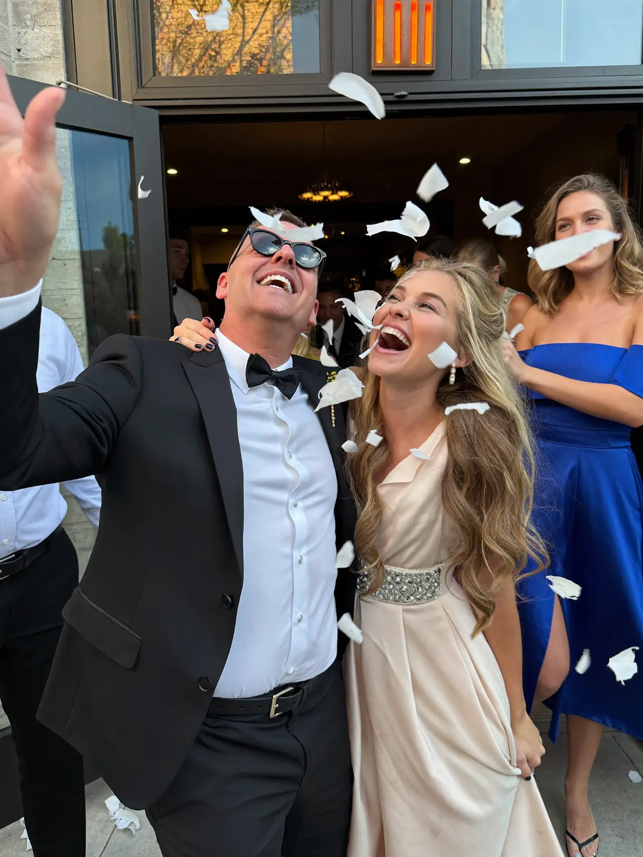Couple laughing under thrown confetti